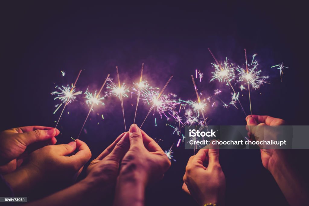 Beautiful sparklers in people hands on black background,holiday and xmas and new year concept. Sparkler - Firework Stock Photo