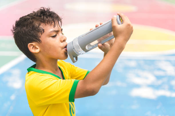 eau potable garçon sur cour - water child bottle little boys photos et images de collection