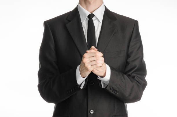 istock Businessman and gesture topic: a man in a black suit with a tie folded his hands in front of him and praying, meditating businessman isolated on a white background in studio 1045478364