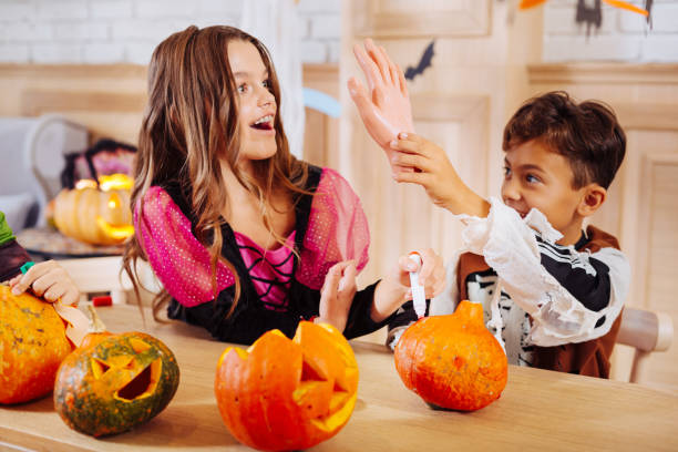 istock Cute boy wearing skeleton Halloween costume plating tricks with older sister 1045486606