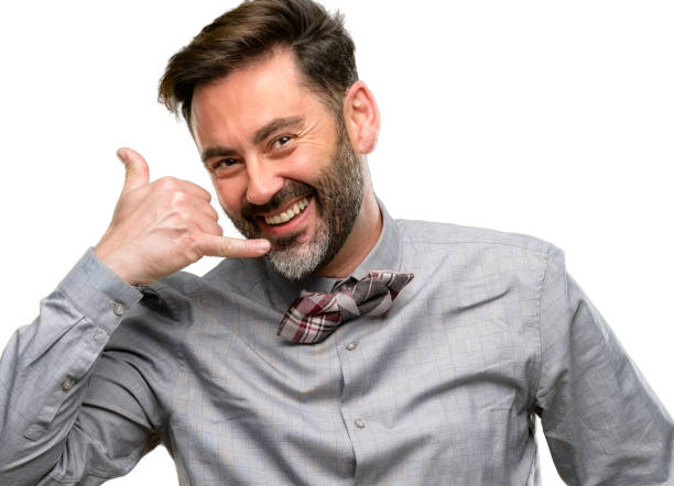 istock Middle age man, with beard and bow tie happy and excited making showing call me gesture with hand shaped like telephone 1045500284