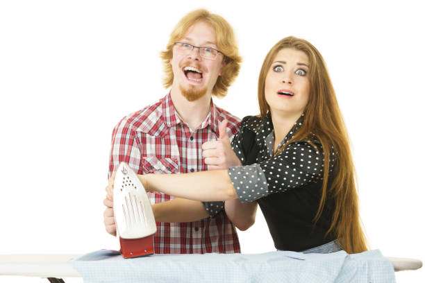 istock Woman teaching men how to do ironing 1045500428