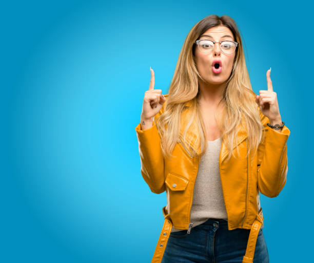 istock happy and surprised cheering expressing wow gesture pointing up 1045504008