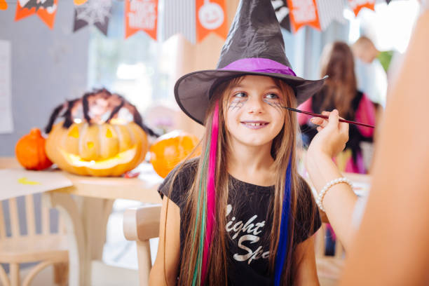 istock Smiling girl with purple lips feeling happy having Halloween wizard makeup 1045504378