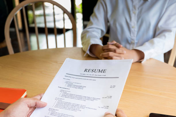istock Woman submits job application, Interviewer reading a resume. 1045506080