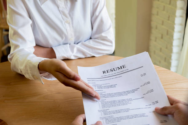 istock Woman submits job application, Interviewer reading a resume. 1045508212