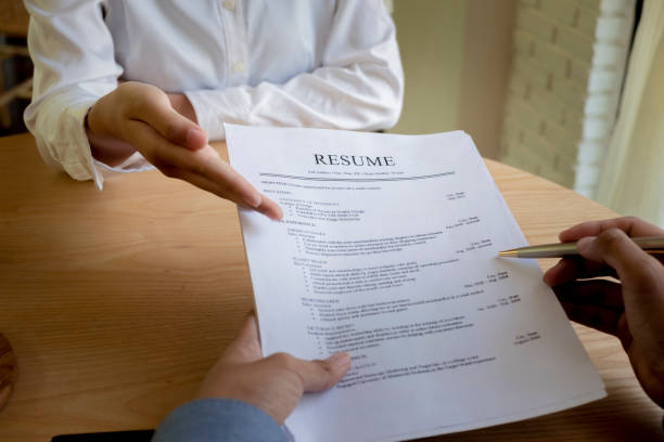 istock Woman submits job application, Interviewer reading a resume. 1045508232