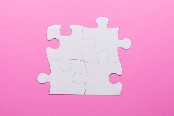 istock White puzzle on pink background. Top view 1045514422
