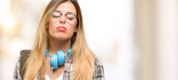 istock Young student woman with headphones and backpack with sleepy expression, being overworked and tired 1045515688
