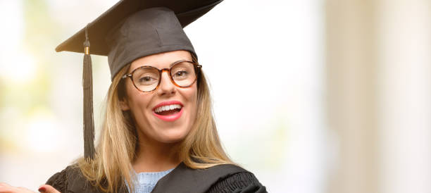 istock Young woman university graduate student holding something in empty hand 1045520780