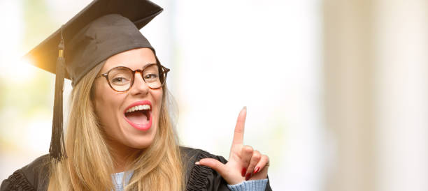 istock Young woman university graduate student pointing away side with finger 1045522996