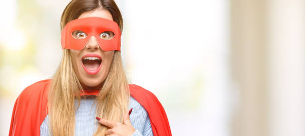 istock Young super woman happy and surprised cheering expressing wow gesture, pointing with finger 1045523076