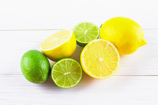 lemons and limes on a wooden background.