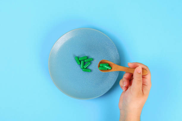 istock Eating pills as a regular meal. Pills on a plate on a blue table background. Top view, copy space, flat lay. 1045523994
