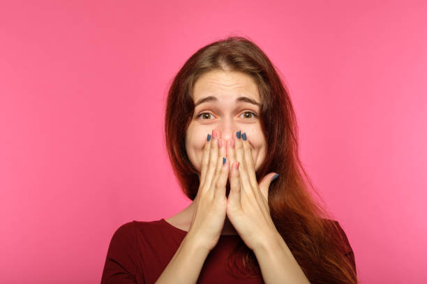istock facial expression joy emotional girl cover mouth 1045528706