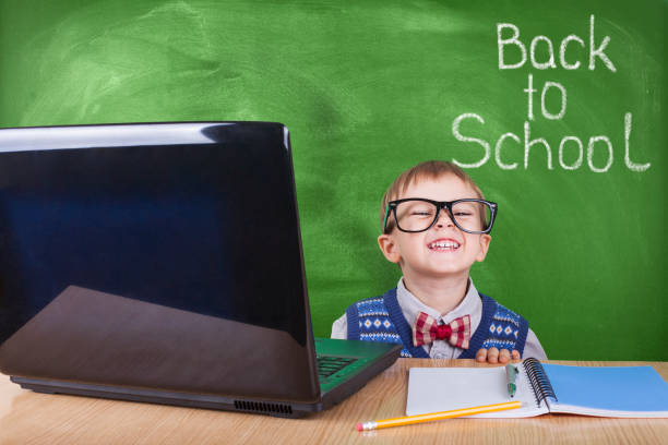 istock Child with laptop peeking in the classroom 1045533940