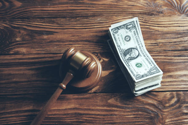 istock hammer and money stack isolated on wooden background 1045540592