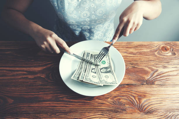 istock Hands cut money on plate reduce funds concept 1045540596