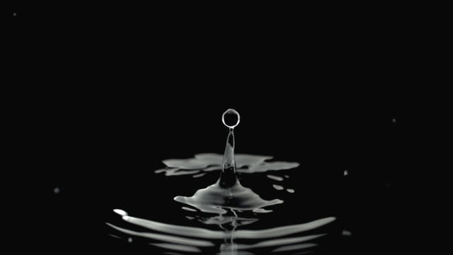 Slow motion water drip, black background