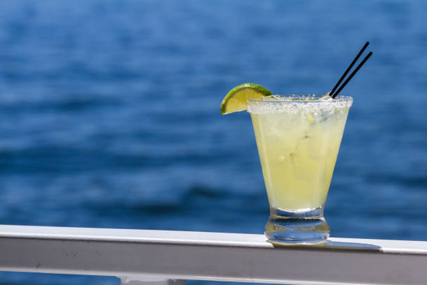 refreshing margarita served outside with a water background as a travel concept