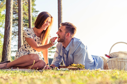 Couple in love enjoying picnic time and food outdoors.