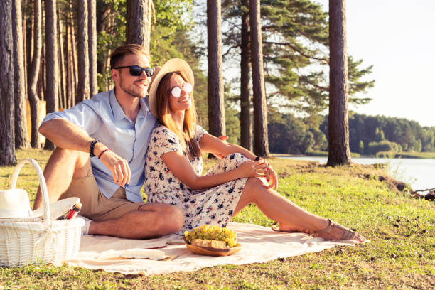 istock Beautiful couple enjoying picnic time on the sunset 1045554784