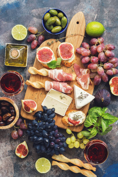 istock A variety of appetizer, prosciutto,grapes, wine, cheese with mold, figs, olives on a rustic background. Mediterranean snack.Top view,flat lay. 1045555186