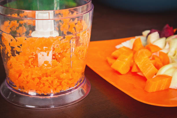 Carrots for borsch in an electric chopper. Soup cooking.