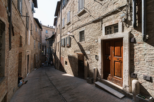 Urbino, Italy – August 29, 2018: A small empty intersection of two sreets from the middle ages in the city of Urbino on a  sunny summer day.