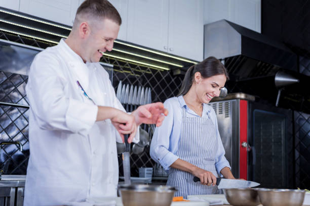 istock Experienced cook showing new methods of cooking to a lady 1045574736