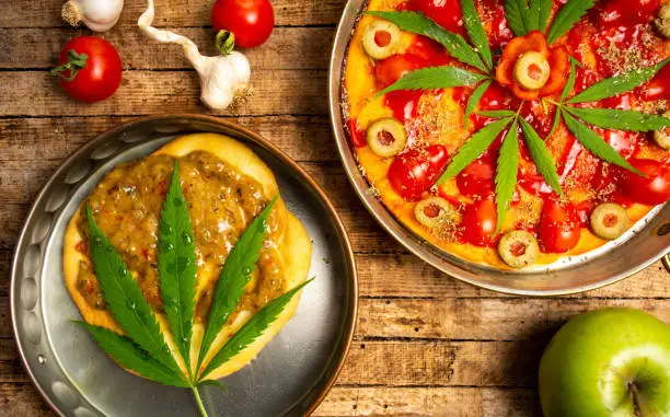 Pizza and pastry with marijuana on a tray top view