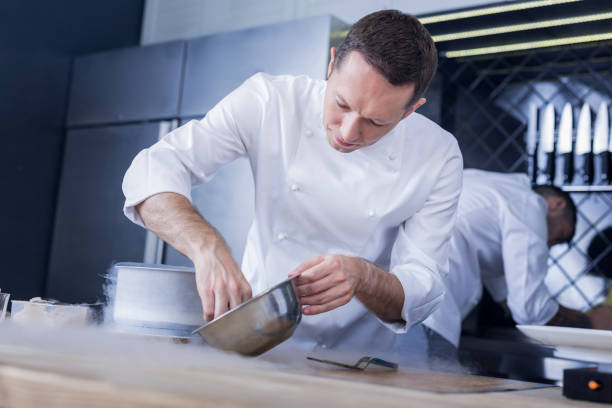 istock Concentrated pleasant cook doing his work perfectly 1045580518