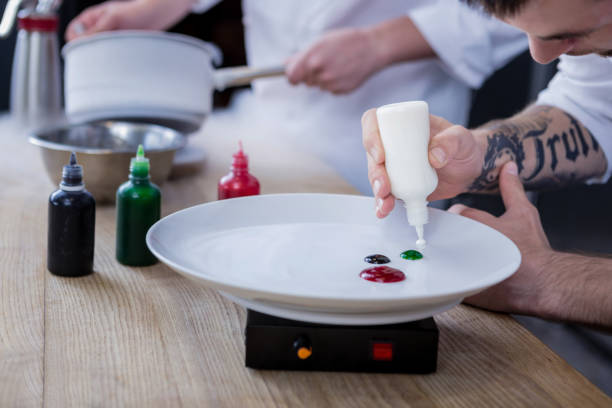 istock Ambitious cook with a tattoo on the hand cooking a dish 1045580634