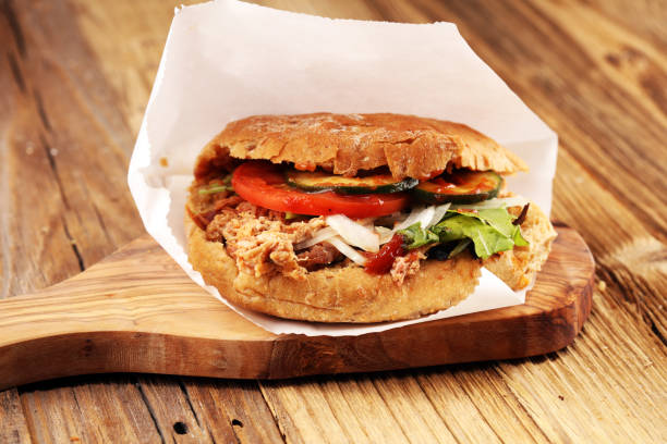 istock Pulled pork sandwiches with BBQ sauce, cabbage and pickles on wooden table 1045581680