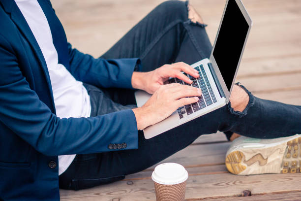 istock Closeup man hand working on wooden bridge with laptop, coffee and notebook 1045602830