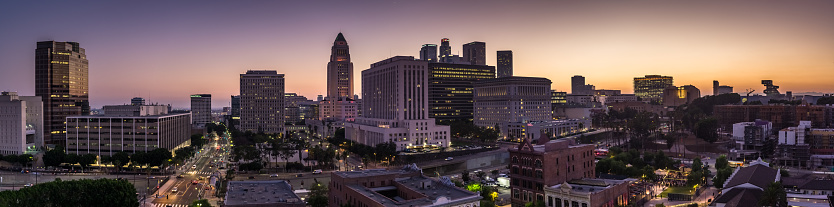 Aerial panorama of Downtown Los Angeles at dusk, with City Hall in the center.