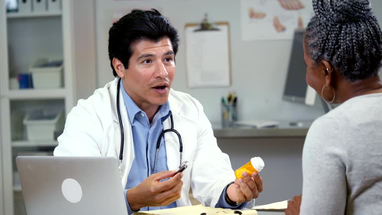 Male doctor discusses prescription drug side effects with female patient