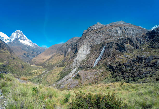 istock waterfalls and snowcapped mountains 1045634984