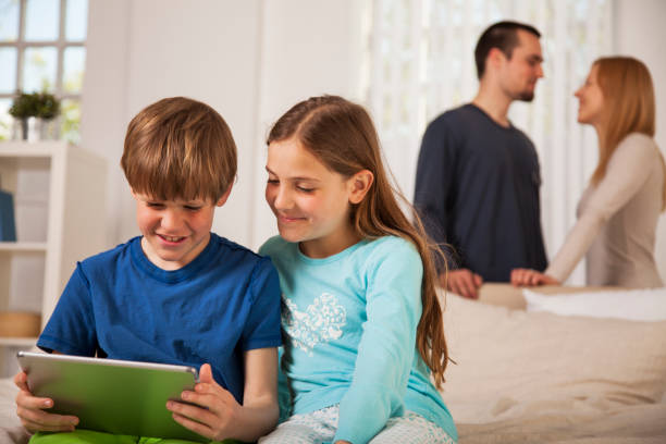istock Children having fun with digital tablet with loving parents in the back 1045641734