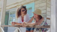 istock Happy women talking on summer beach house patio 1045647068