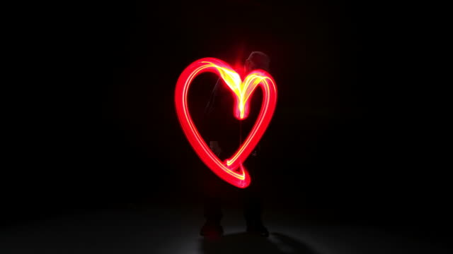 Man painting heart shape with light, stop motion