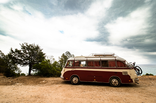 CALA GONONE - SARDINIA - ITALY - JULY 01, 2014: Classic Red and white Volkswagen camper parked on seafront promenade