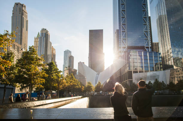 una coppia è in piedi di fronte al ground zero memorial a manhattan. world trade center, noto anche come "ground zero" dopo gli attacchi dell'11 settembre. - world trade center september 11 new york city manhattan foto e immagini stock