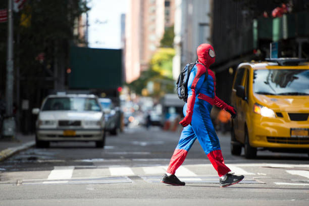 een man die draagt een spiderman-kostuum is wandelen door de straten van manhattan in new york city, verenigde staten. - spider man stockfoto's en -beelden