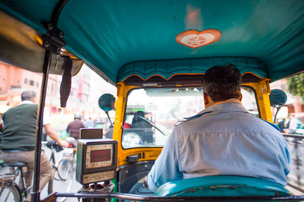 un conducteur de pousse-pousse (également connu sous le nom de tuc tuc) est conduite dans les rues d’agra en inde. agra est une ville sur les rives de la rivière yamuna, dans le nord de l’état de l’uttar pradesh - business traditional culture journey india photos et images de collection