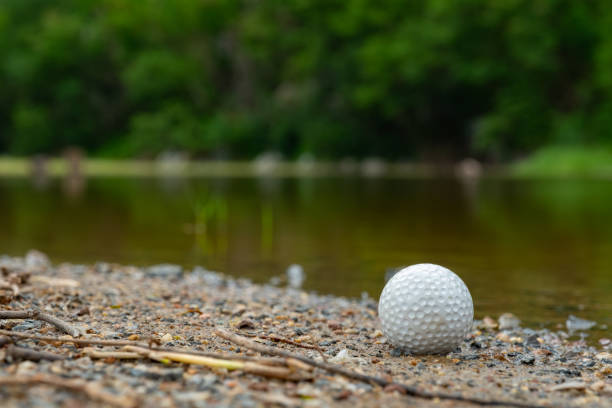 istock Golf ball on grass near small lake 1045652924