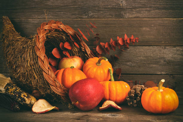 istock Thanksgiving cornucopia with pumpkins and apples against wood 1045665078