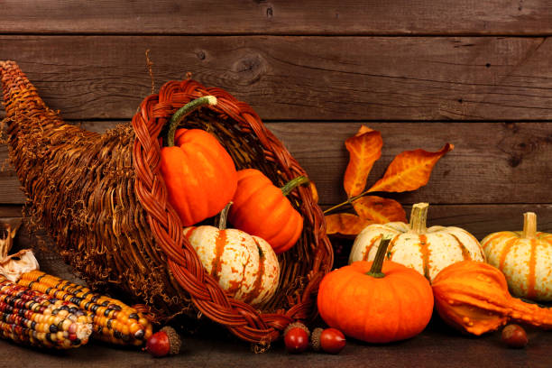istock Thanksgiving cornucopia with pumpkins against rustic wood 1045669328