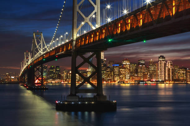 Bay Bridge at night with Christmas-decorated San Francisco downtown in the background