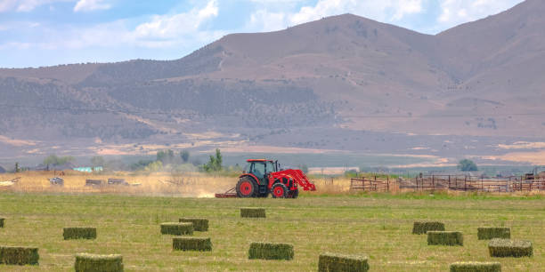 istock Red tractor on a field with view of mountain 1045693472